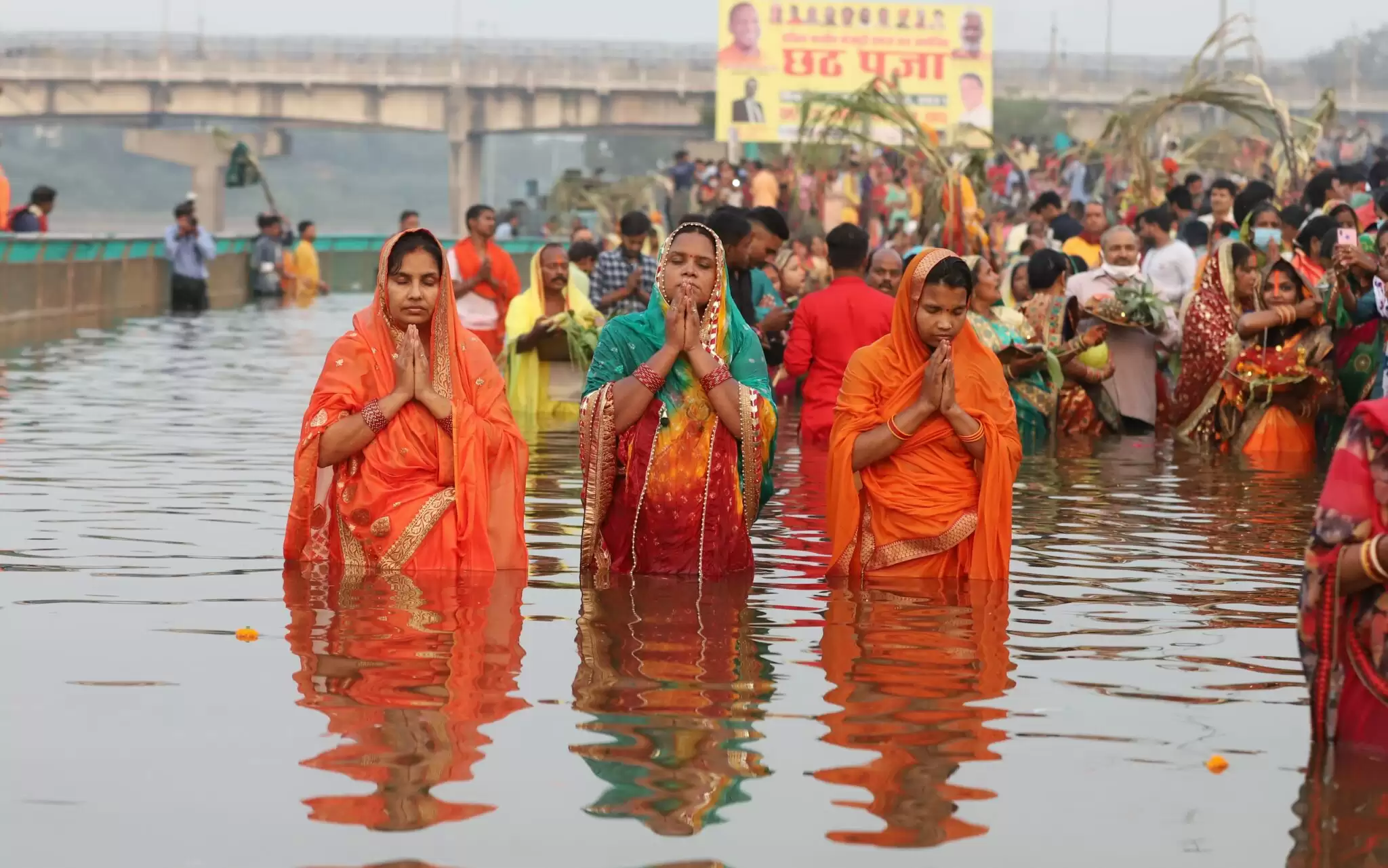 लखनऊ में गोमती नदी के तट पर छठ पूजा करती महिला