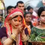 लखनऊ में गोमती नदी के तट पर छठ पूजा करती महिला