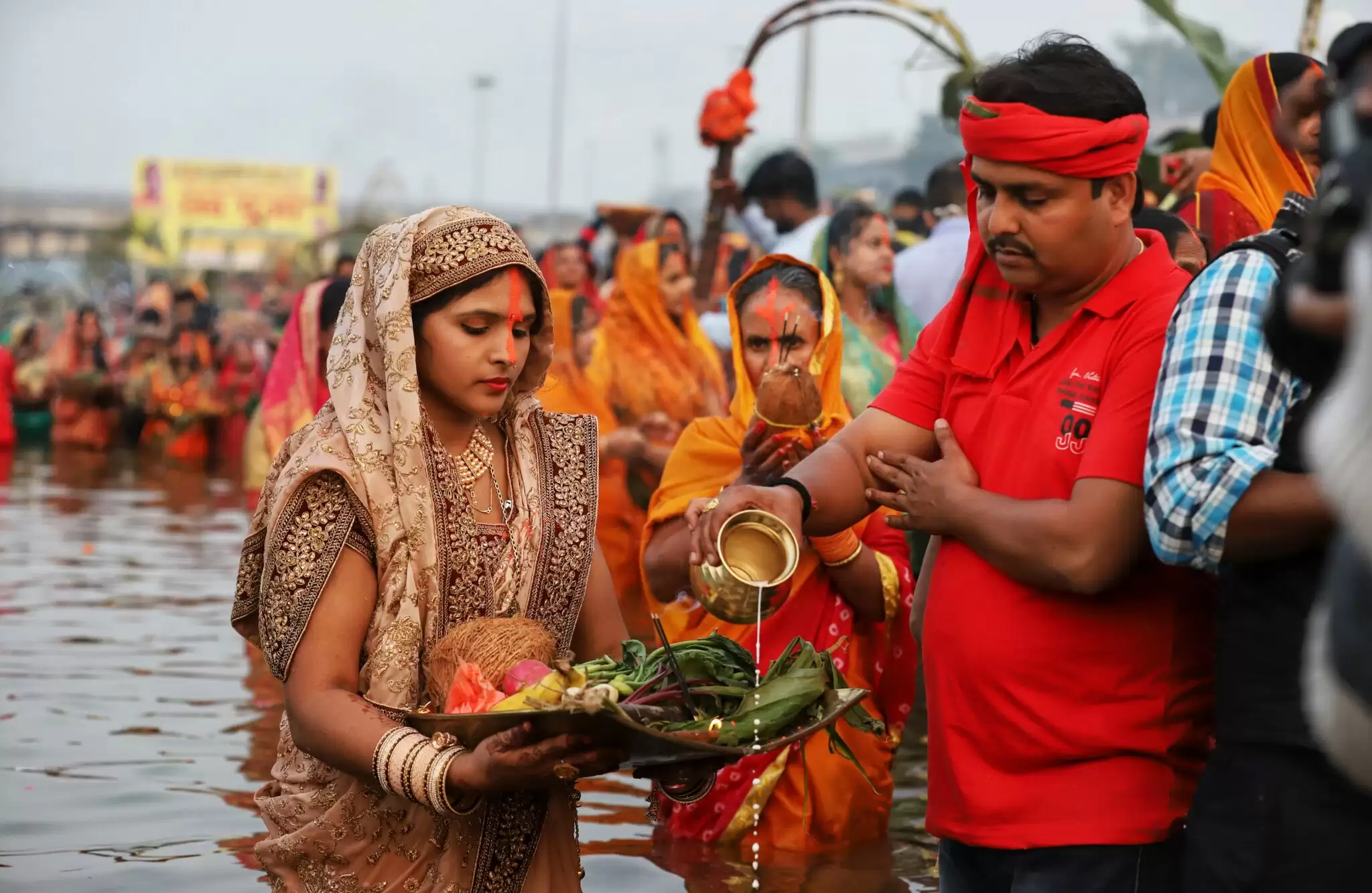 लखनऊ में गोमती नदी के तट पर छठ पूजा करती महिला